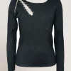 Maglia con spacco e catena sulla spalla